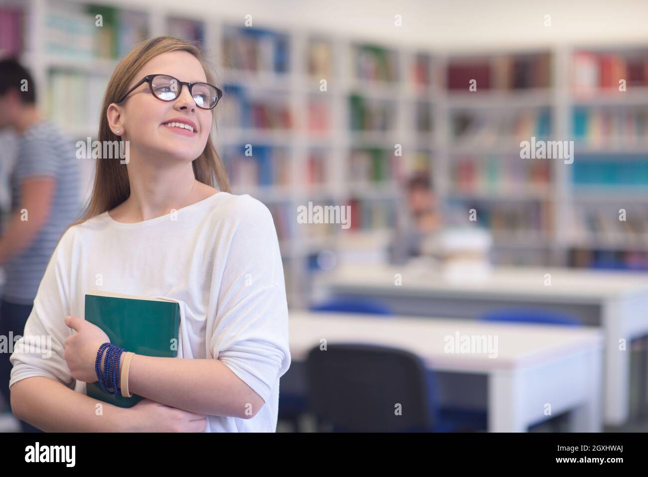 portrait of happy smilling female student girl in school library ...
