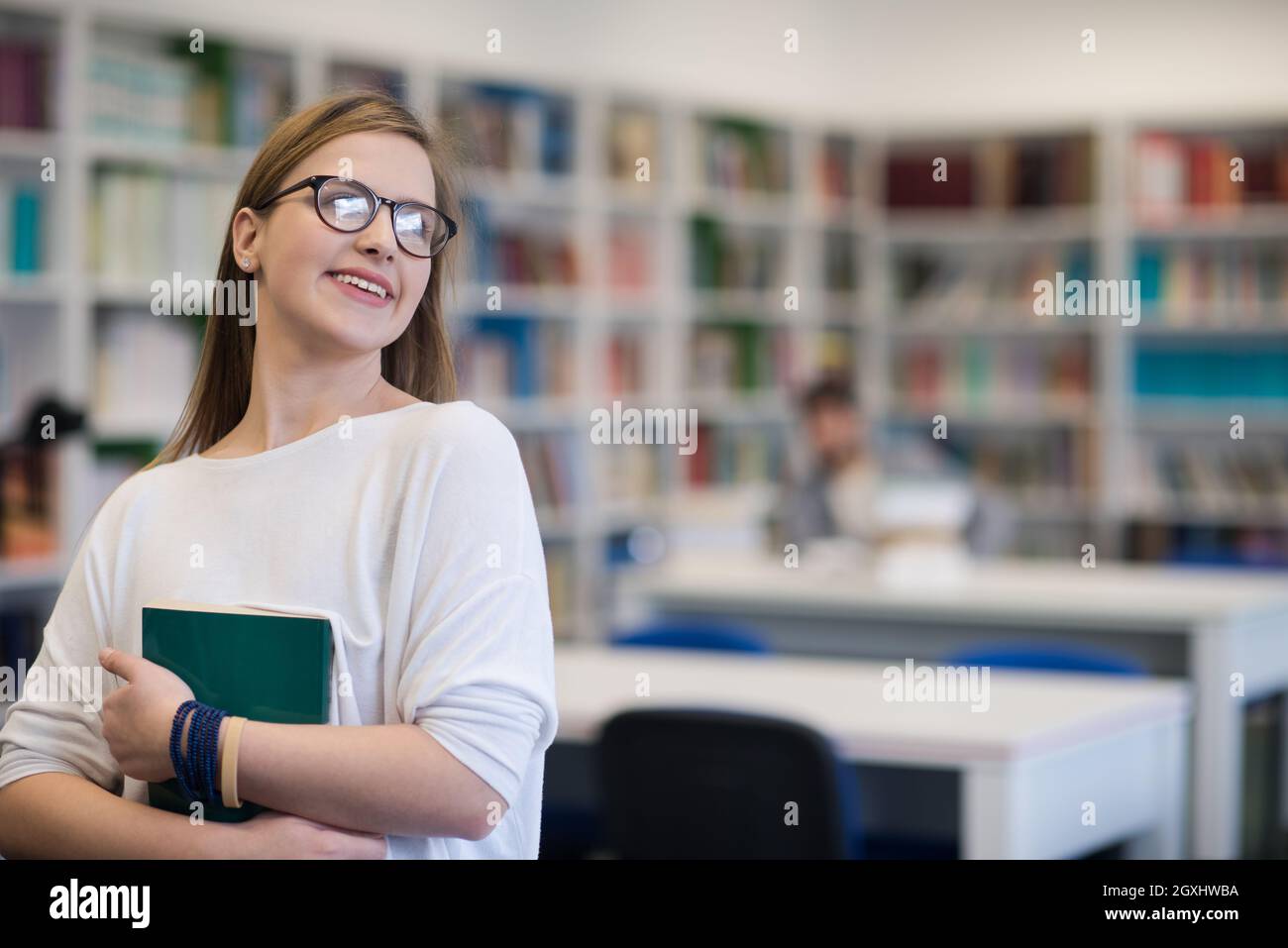 portrait of happy smilling female student girl in school library ...