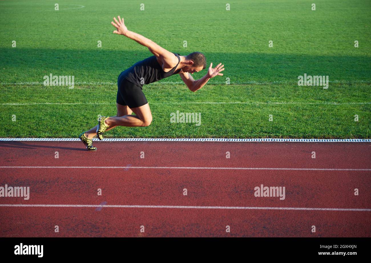 Sprinter leaving starting blocks on the running track. Explosive start Stock Photo Alamy