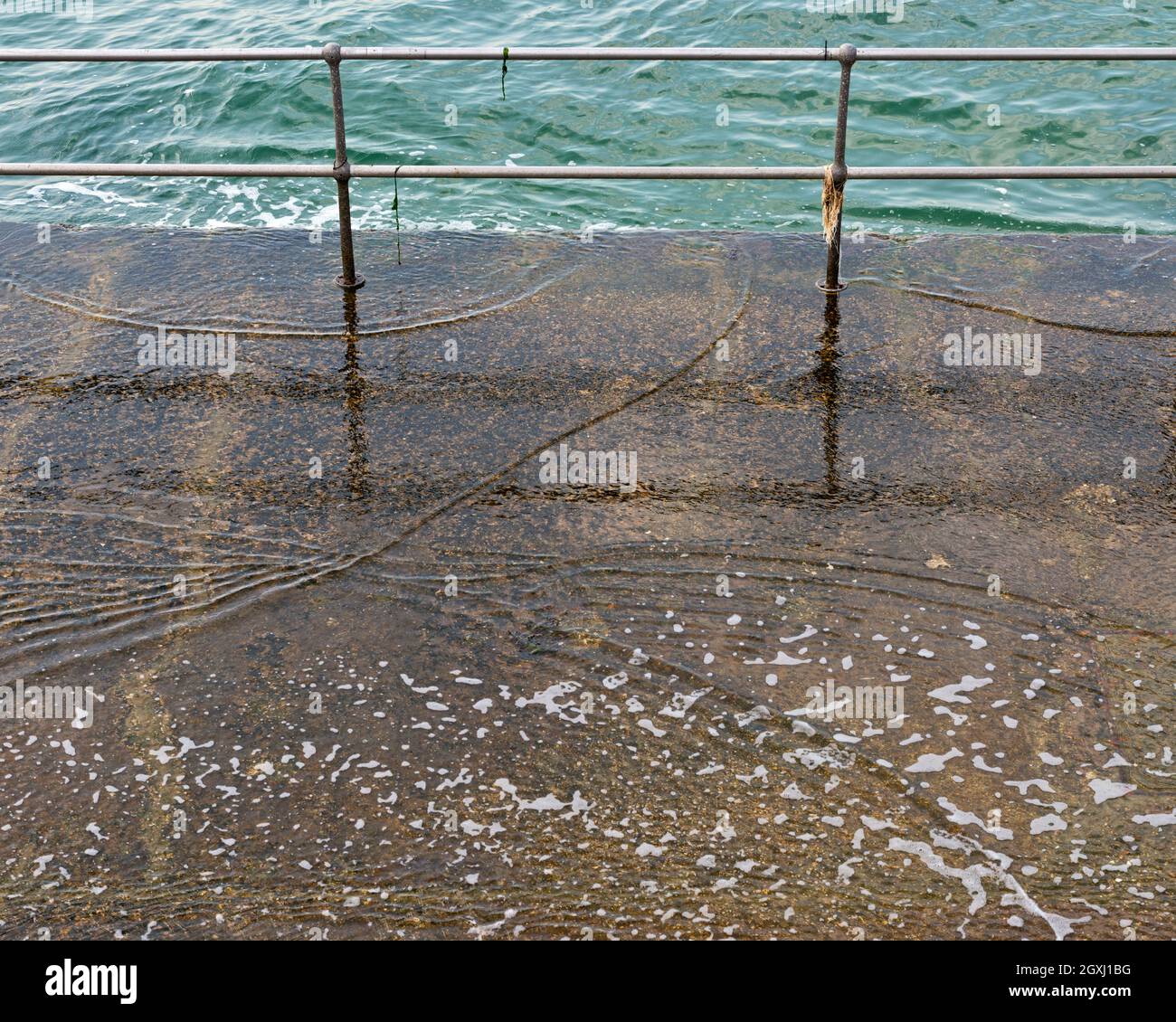 looking down at water lapping on to a concrete jetty at the Hot Walls by the Square Tower on the seafront at Old Portsmouth, Portsmouth, Hampshire, UK Stock Photo