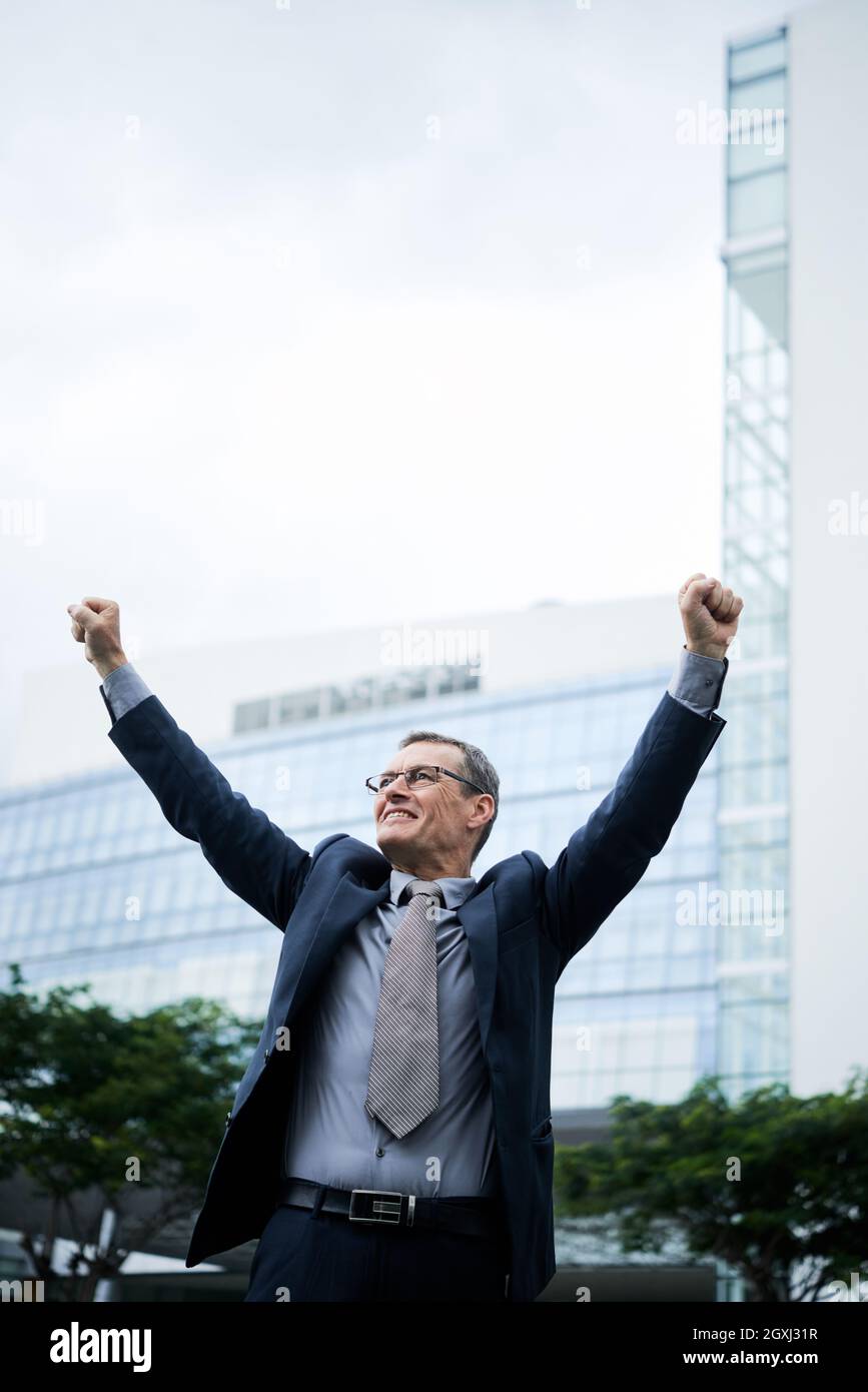 Excited mature Caucasian businessman in glasses and suit walking with ...