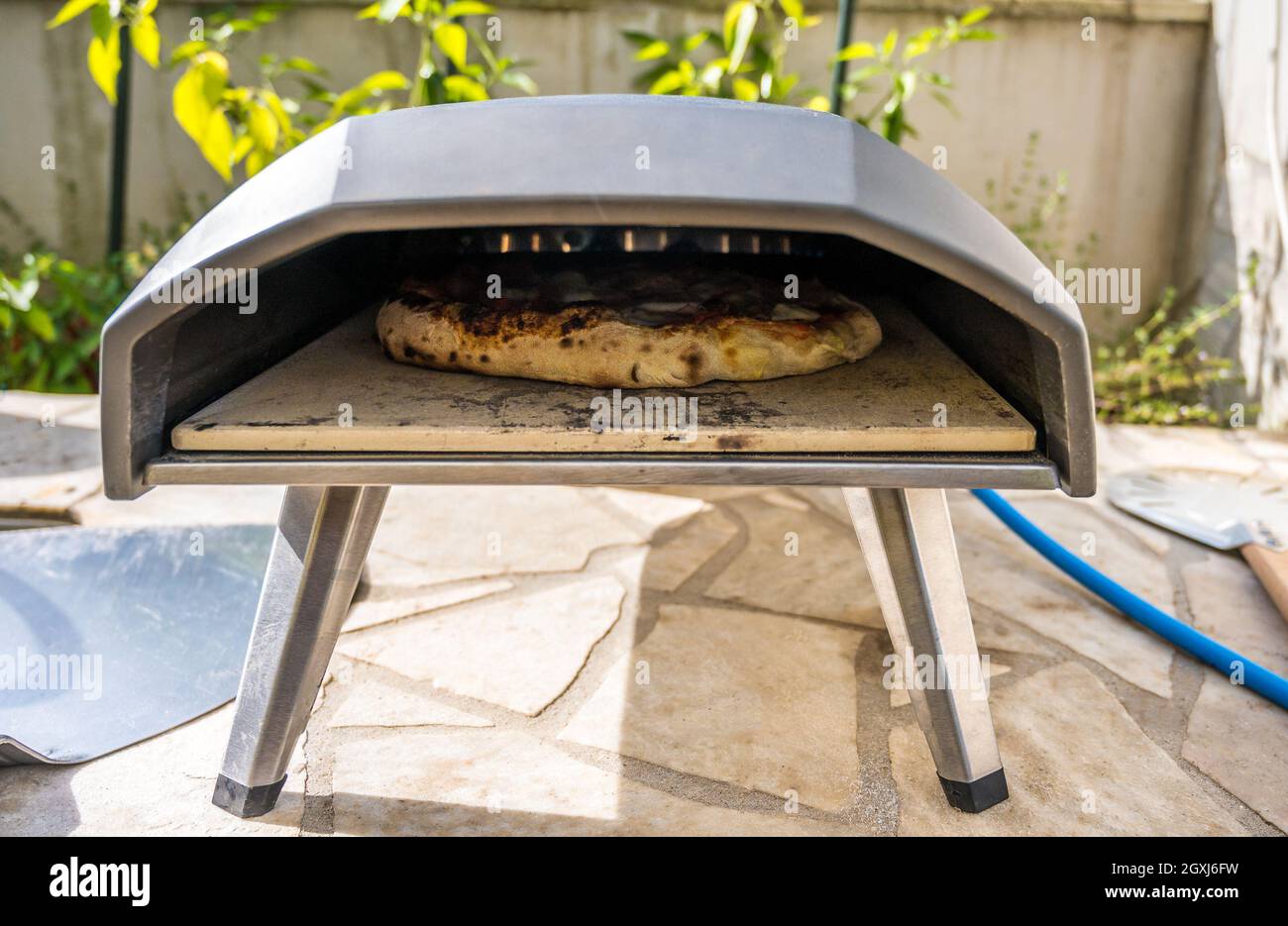 Making homemade pizza in portable high temperature gas pizza oven.  Delicious pizza is baking in gas oven furnace for home made Neapolitan  pizza. Speci Stock Photo - Alamy