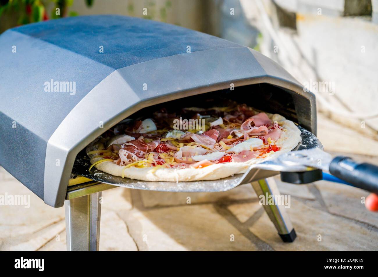 Making homemade pizza in portable high temperature gas pizza oven