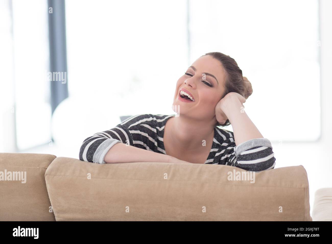portrait of a young beautiful woman sitting on the sofa at home Stock ...