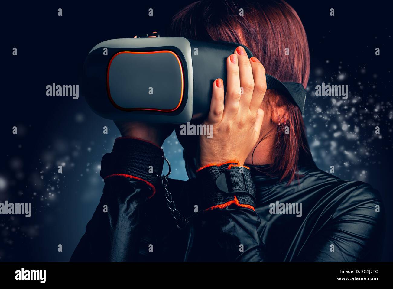 Sexy Woman with handcuffs and latex dress enjoying virtual reality at home. Concept Virtual Love Stock Photo
