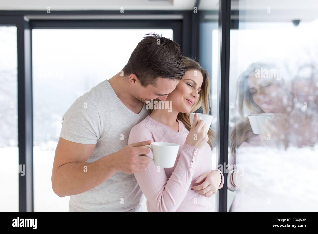 romantic happy young couple enjoying morning coffee by the window on