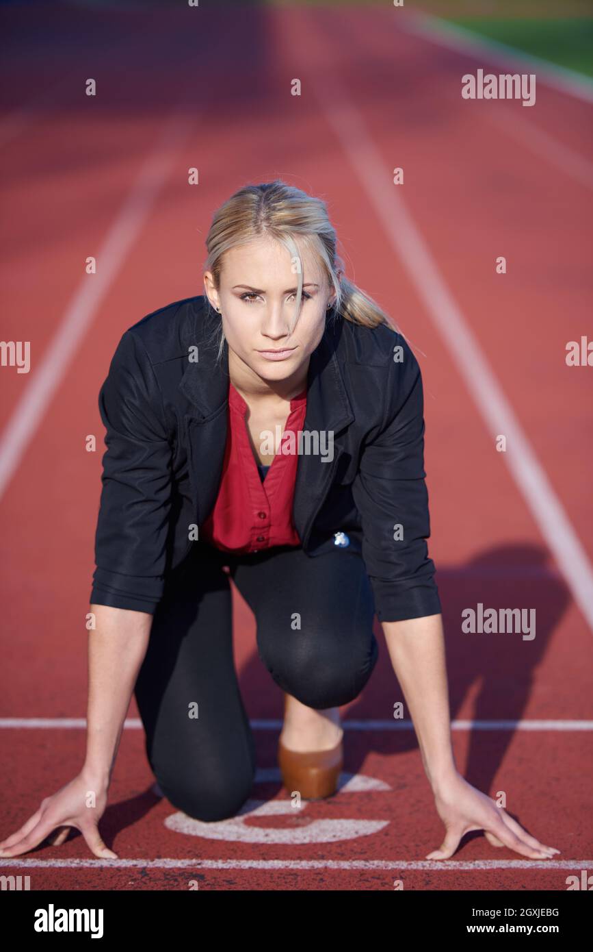 business woman in start position ready to run and sprint on athletics racing track Stock Photo