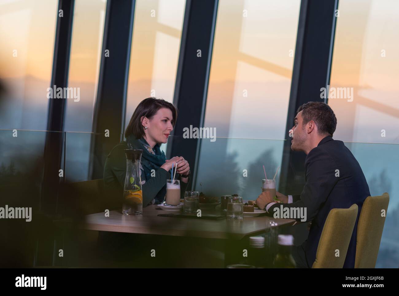 young happy loving couple enjoying romantic dinner while celebrating ...