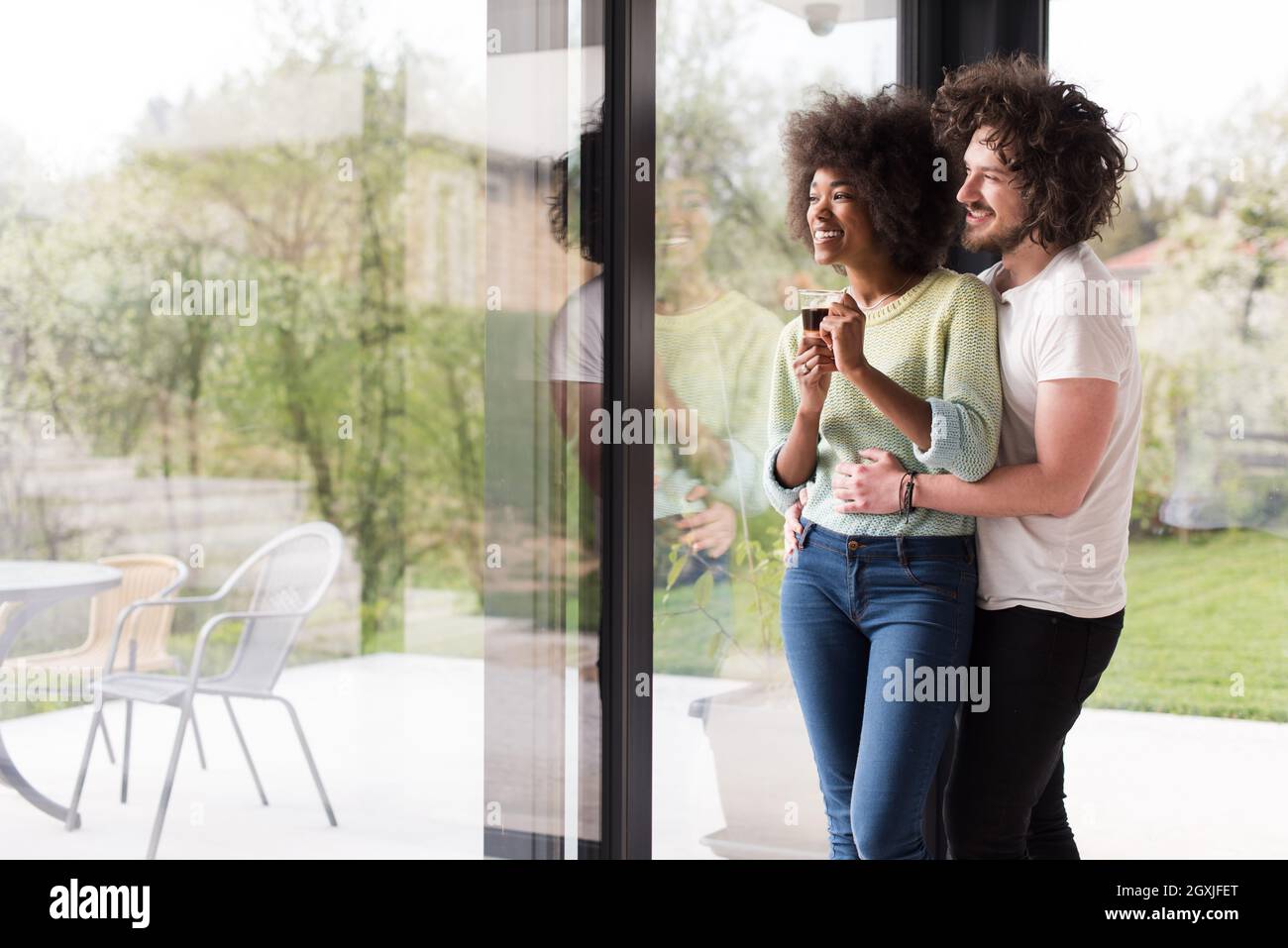 romantic happy young multiethnic couple enjoying morning coffee by the ...