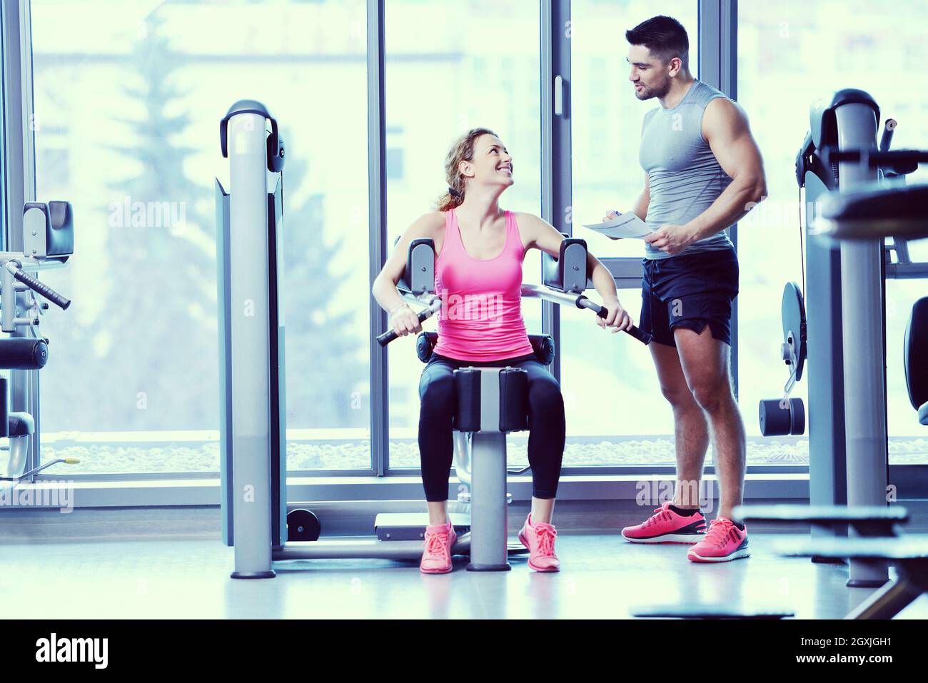 Gym woman exercising with her personal trainer Stock Photo - Alamy