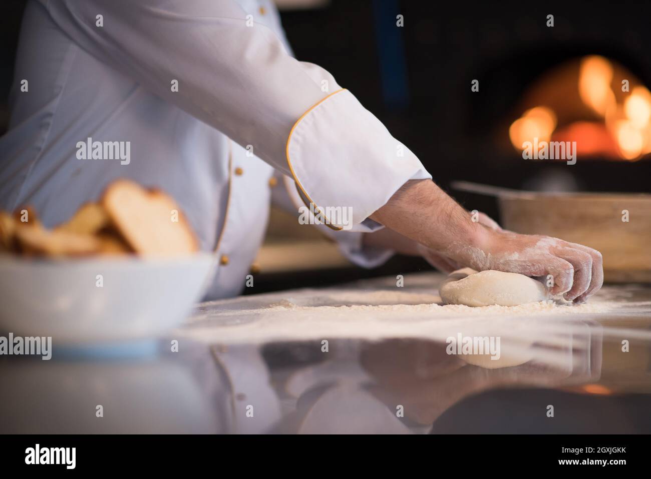chef hands preparing dough for pizza on table sprinkled with flour ...
