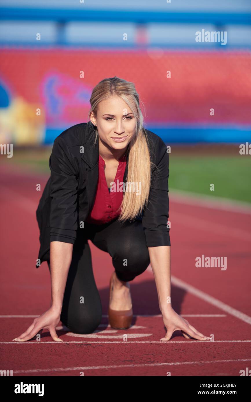 business woman in start position ready to run and sprint on athletics racing track Stock Photo