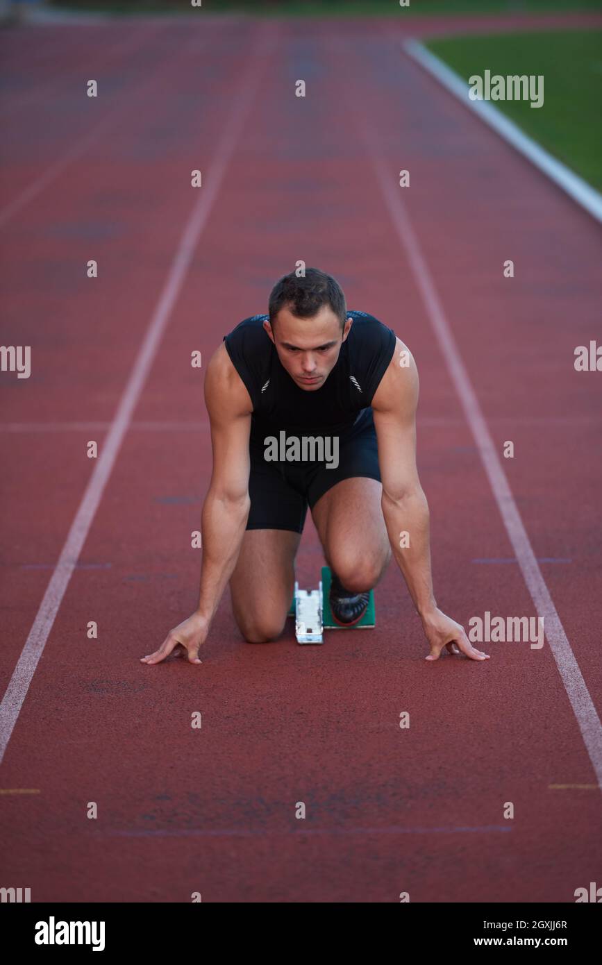 Sprinter leaving starting blocks on the running track. Explosive start ...
