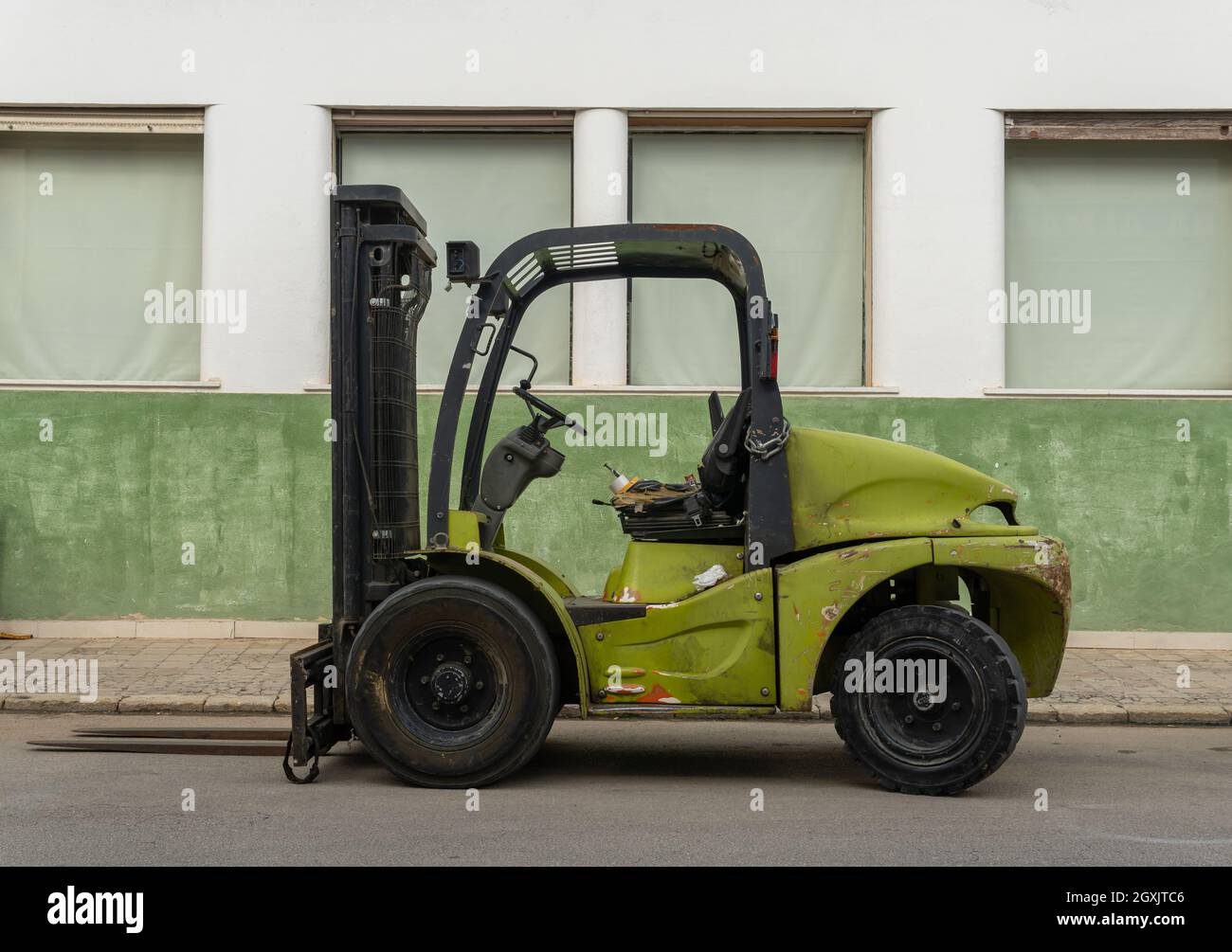 Llucmajor, Spain; october 03 2021: Green forklift parked on an industrial street. Island of Mallorca, Spain Stock Photo