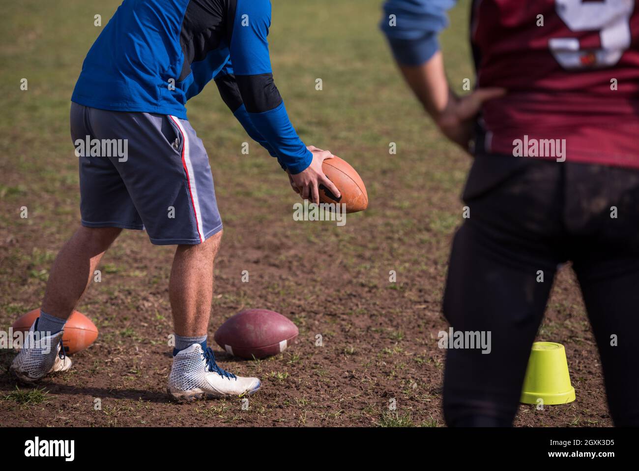 Team coach throwing the ball into the group of young american football players in action during