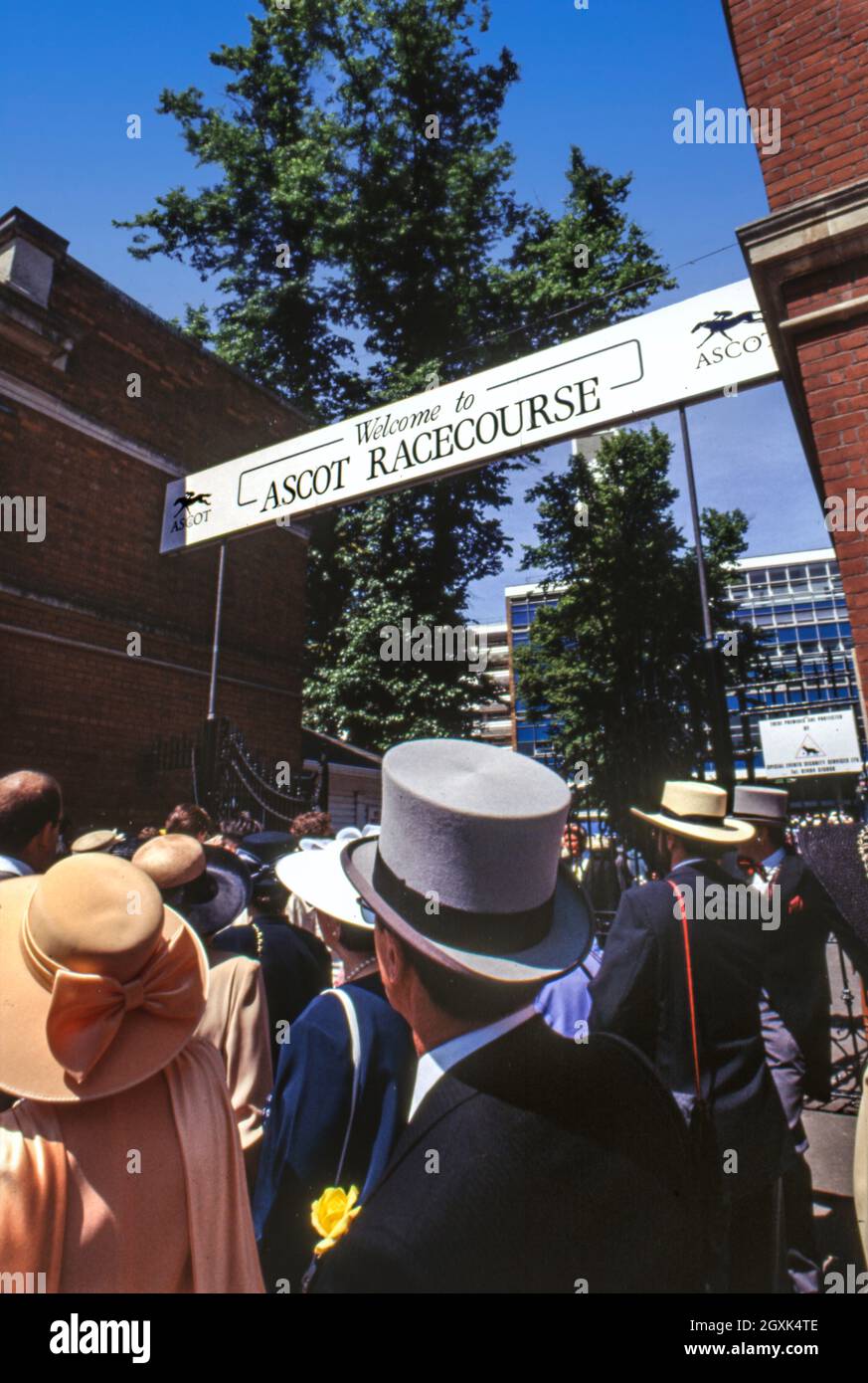 1990s Ladies Day at Royal Ascot. Racegoers walking into the 1980s architecture Ascot Racecourse entrance wearing the fashion and styles of the day Stock Photo