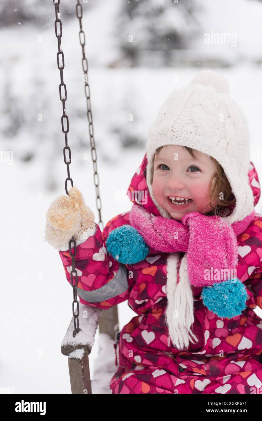 child outdoor in park at winter day with fresh snow, cute little girl