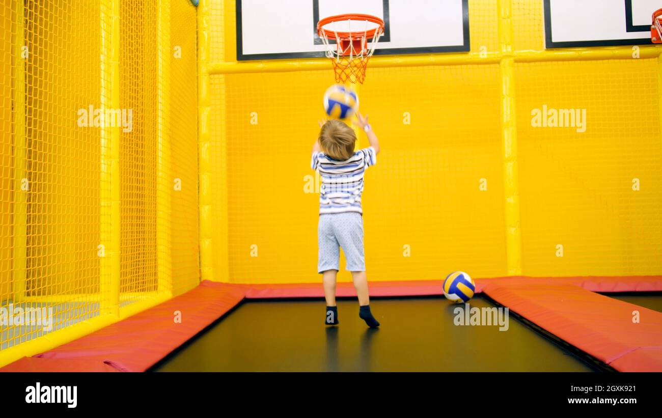 Cute little boy playing in basketball on playground at amusement park