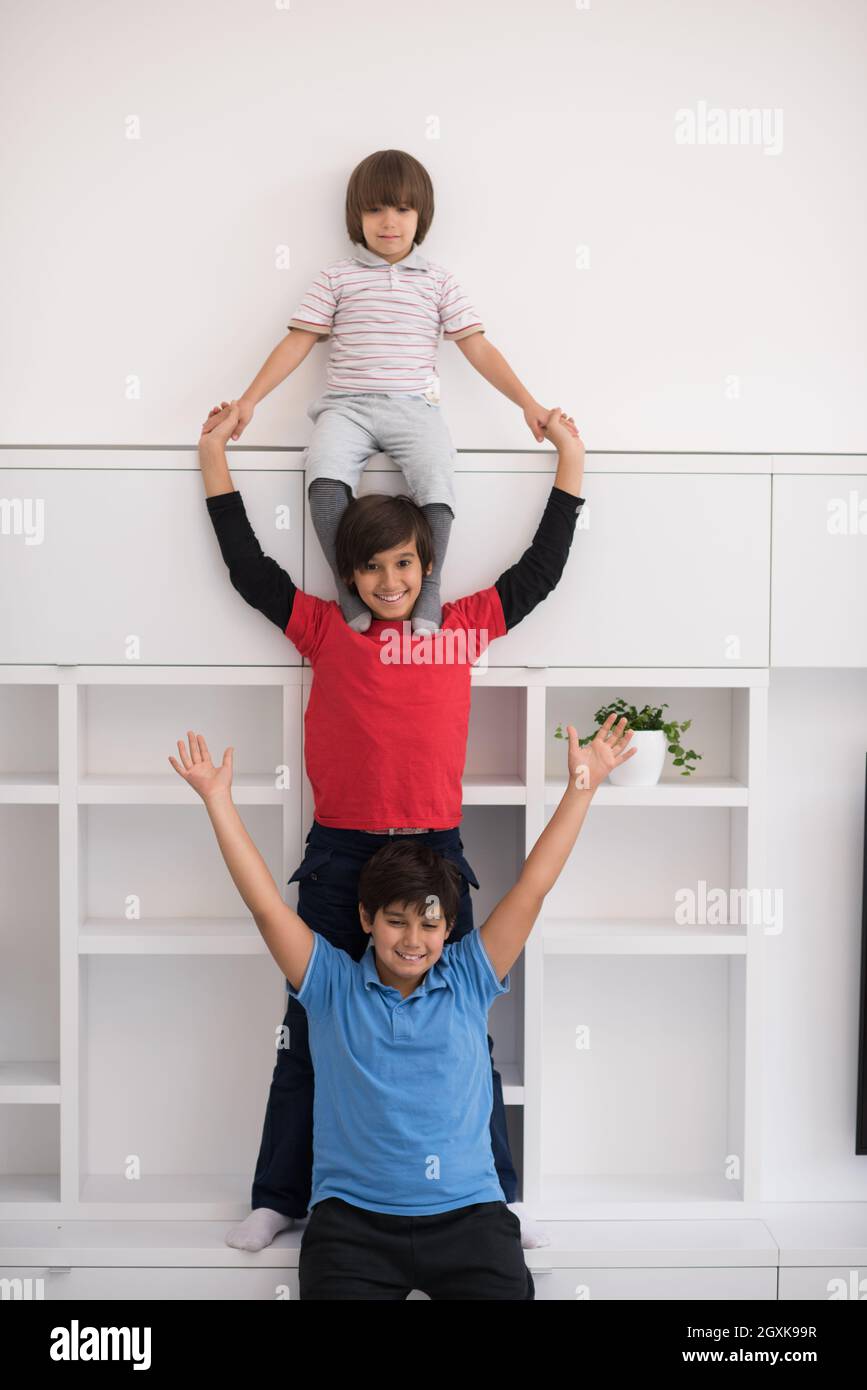 happy young boys having fun and posing line up piggyback in new modern ...