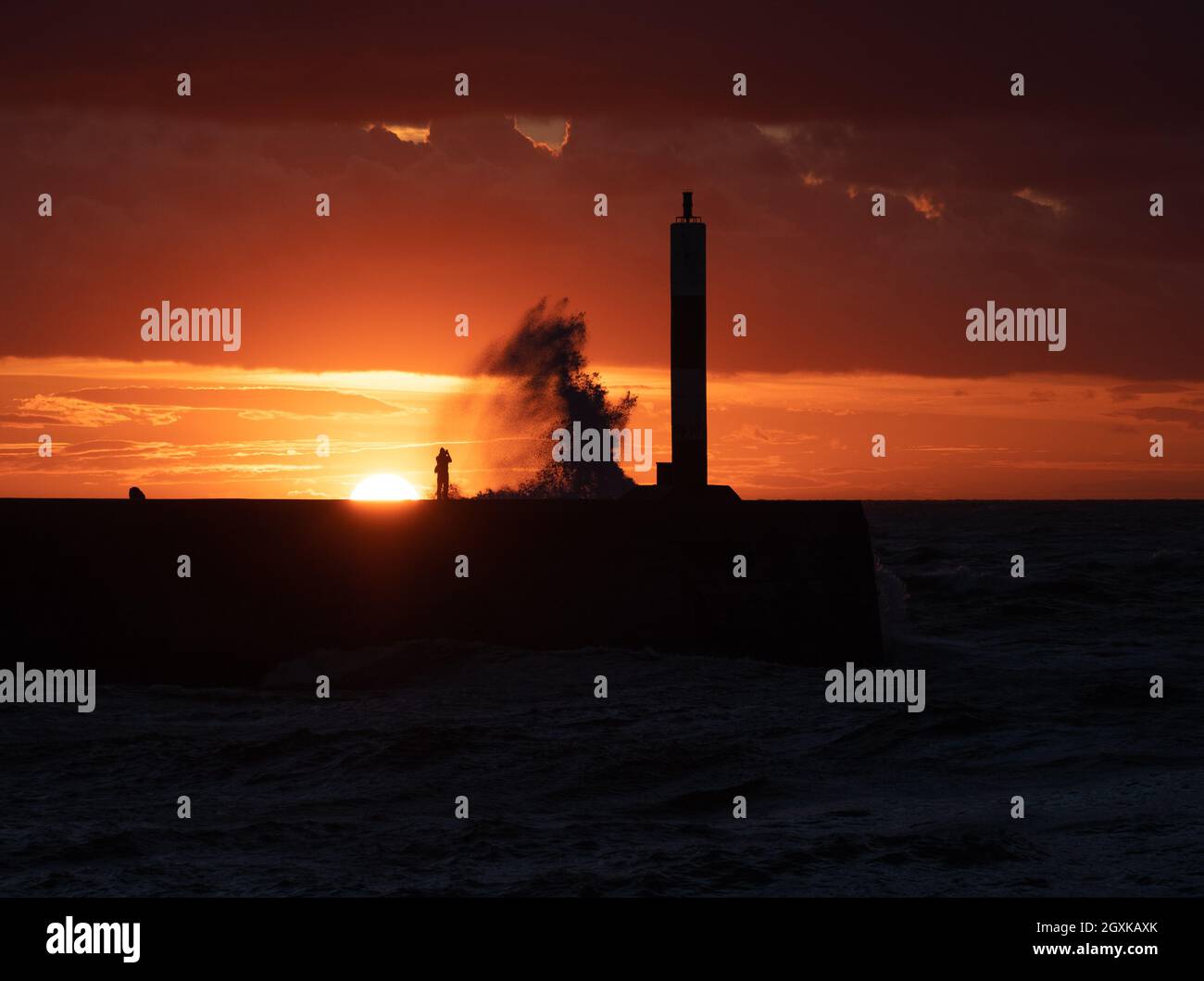 Aberystwyth, Ceredigion, Wales, UK. 5th October 2021 UK weather. A photographer enjoys the last of the sun while the storm starts in the coastal town of Aberystwyth. © Rhodri Jones/Alamy Live News Stock Photo