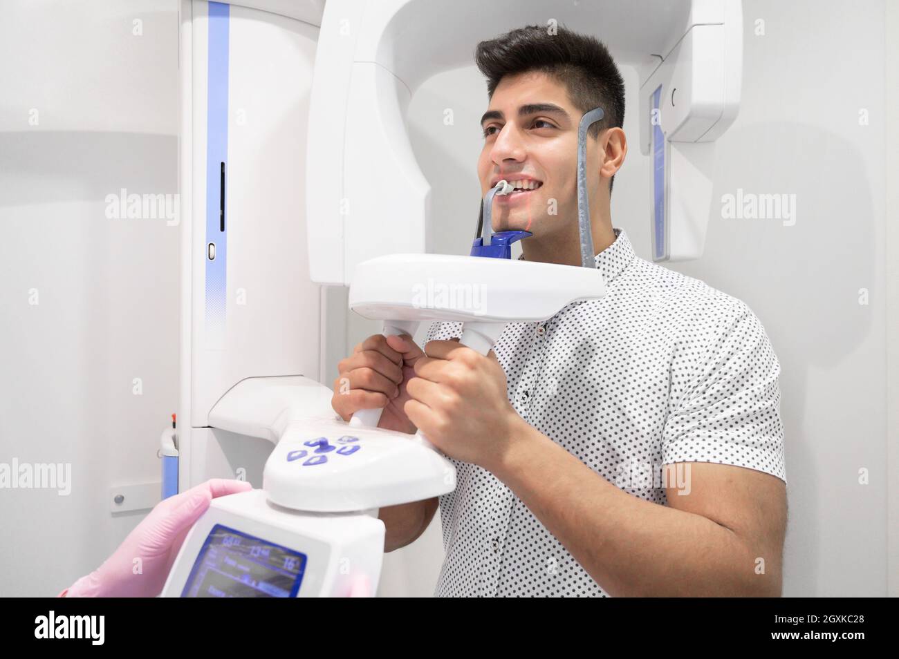 Young man patient standing in x-ray machine. Panoramic radiography. High quality photo. Stock Photo