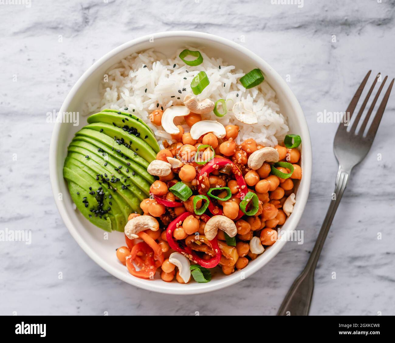 Bowl of basmati rice, chickpea and cashew nut stir fry with avocado