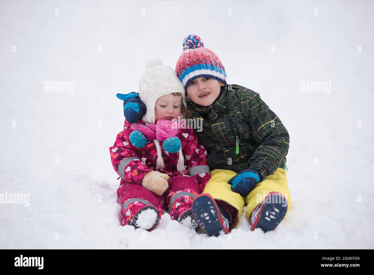 group of children having fun and play together in fresh snow on winter ...