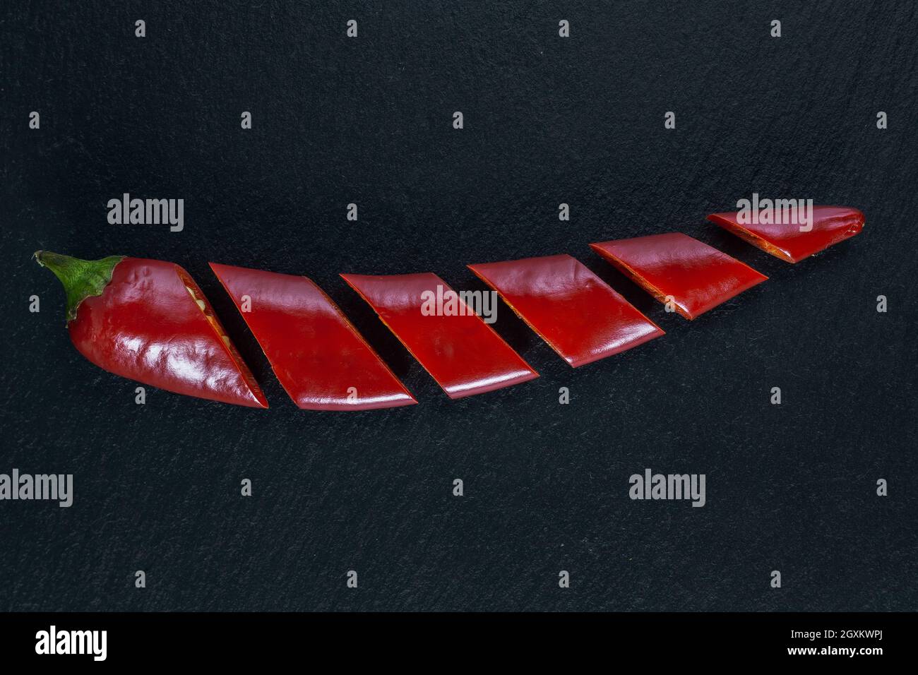 One sliced chilli pepper isolated on black background. Flat lay. Stock Photo