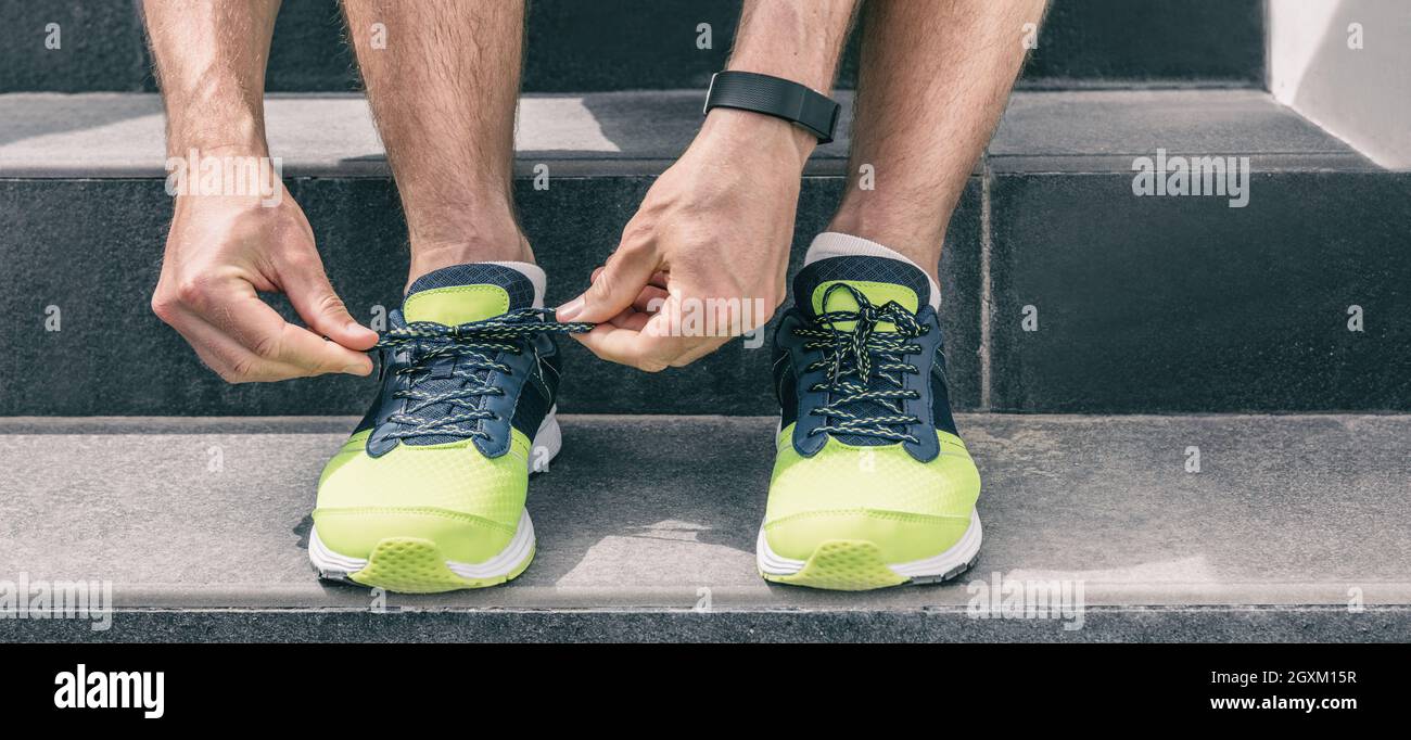Sport workout fit runner man getting ready to run tying shoe laces