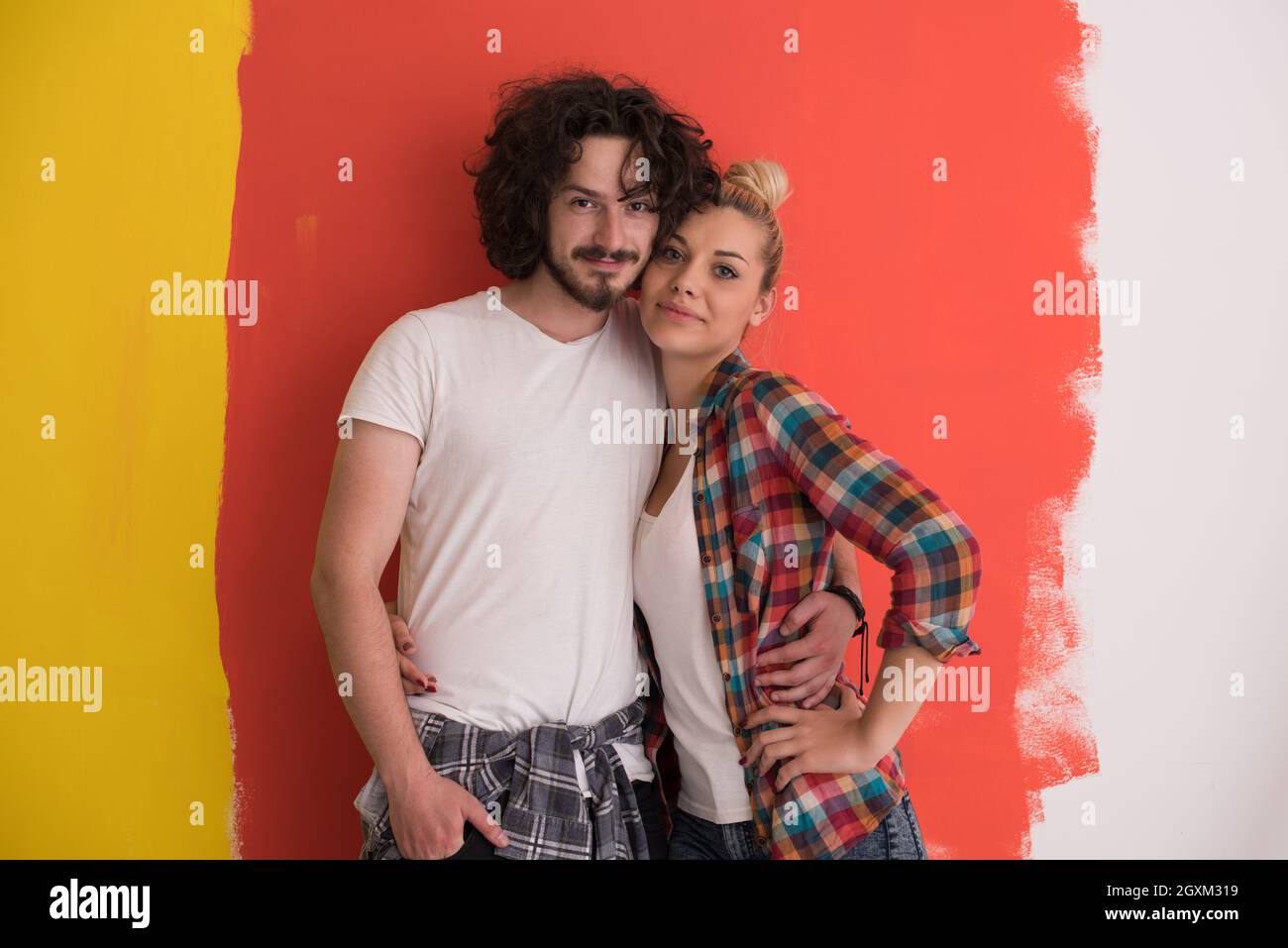 Portrait of a happy young smiling couple in love over color background ...