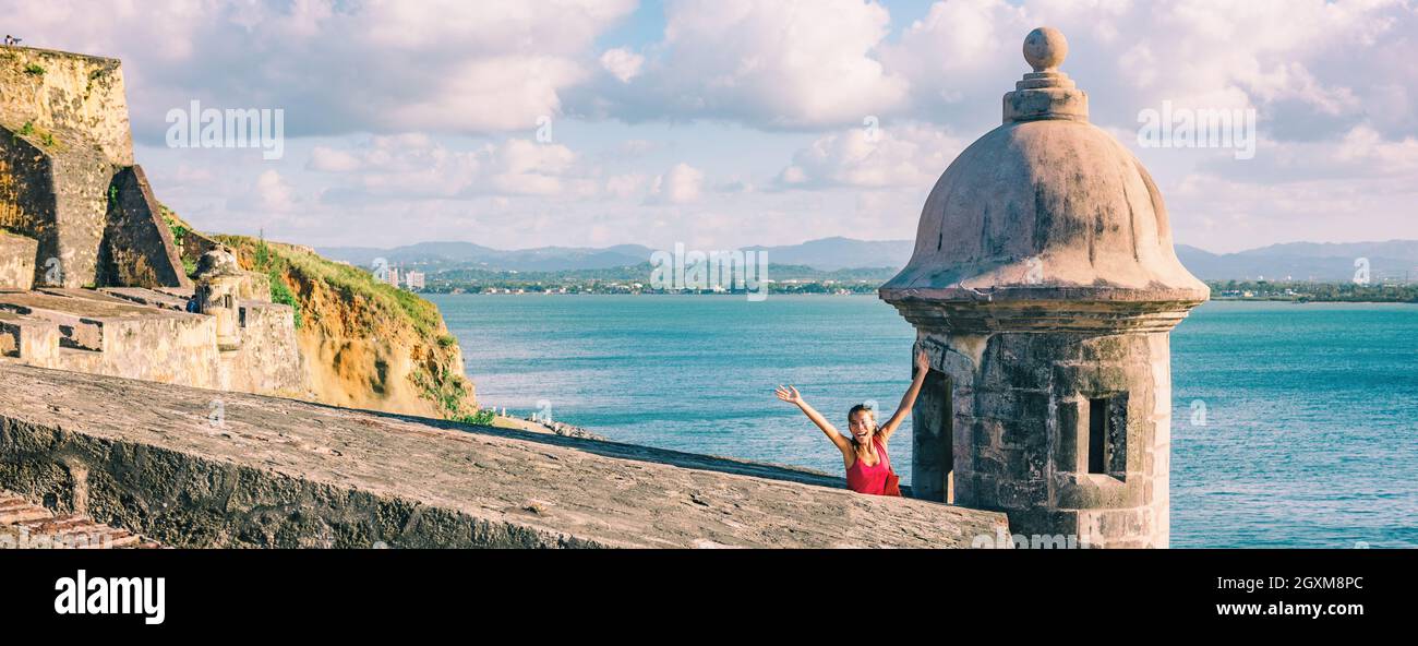 San Juan Puerto Rico travel happy tourist woman waving open arms in happiness at watch tower of Castillo San Felipe del Morro panoramic banner Stock Photo