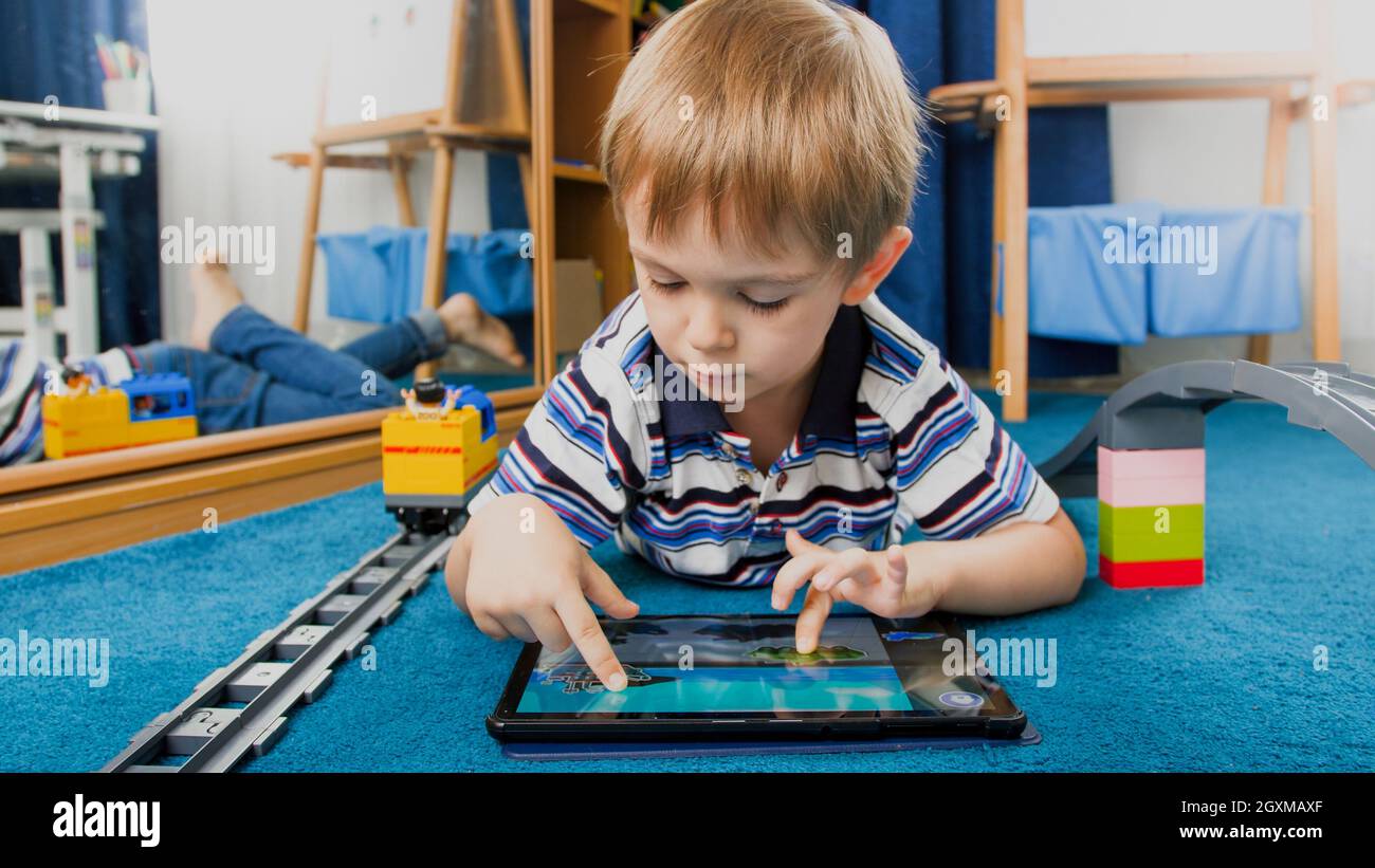 Portrait of smiling boy using pad computer for playing games Stock ...