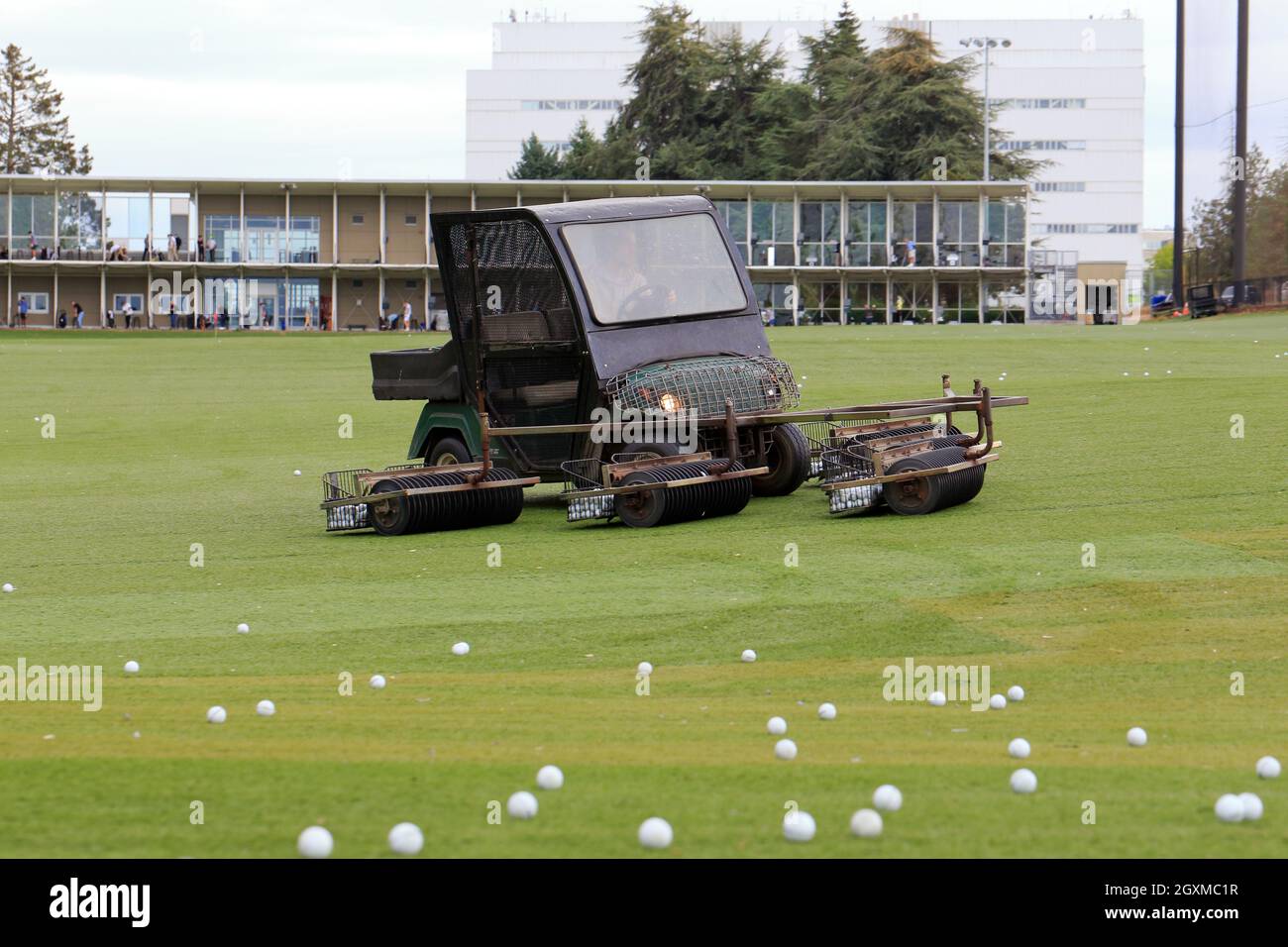 A golf cart equipped with a golf ball retriever at a driving range in
