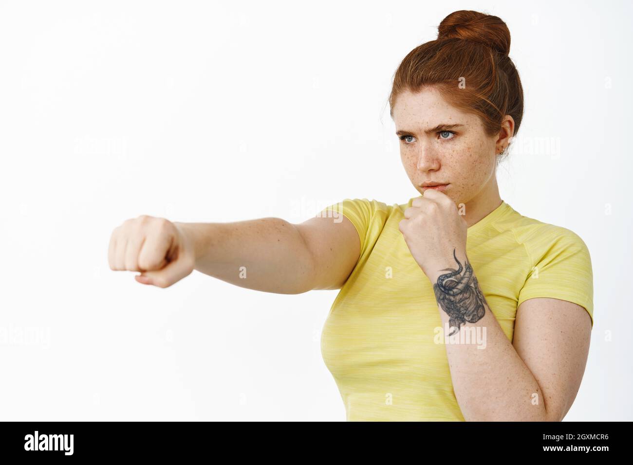 Portrait of serious redhead fitness girl, stretch out clenched fist