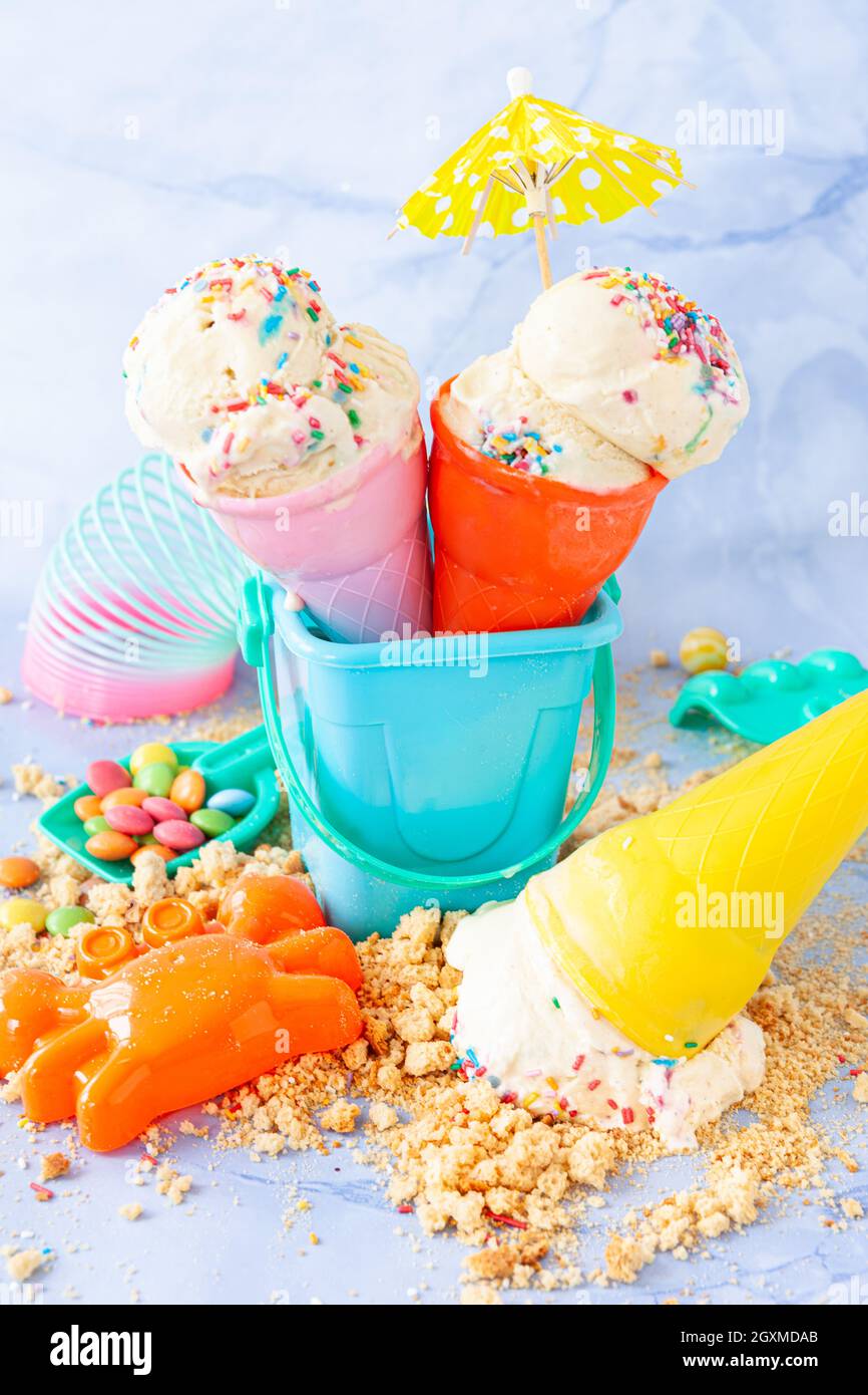 Vanilla ice cream with colorful sugar sprinkles with colorful beach toys Stock Photo
