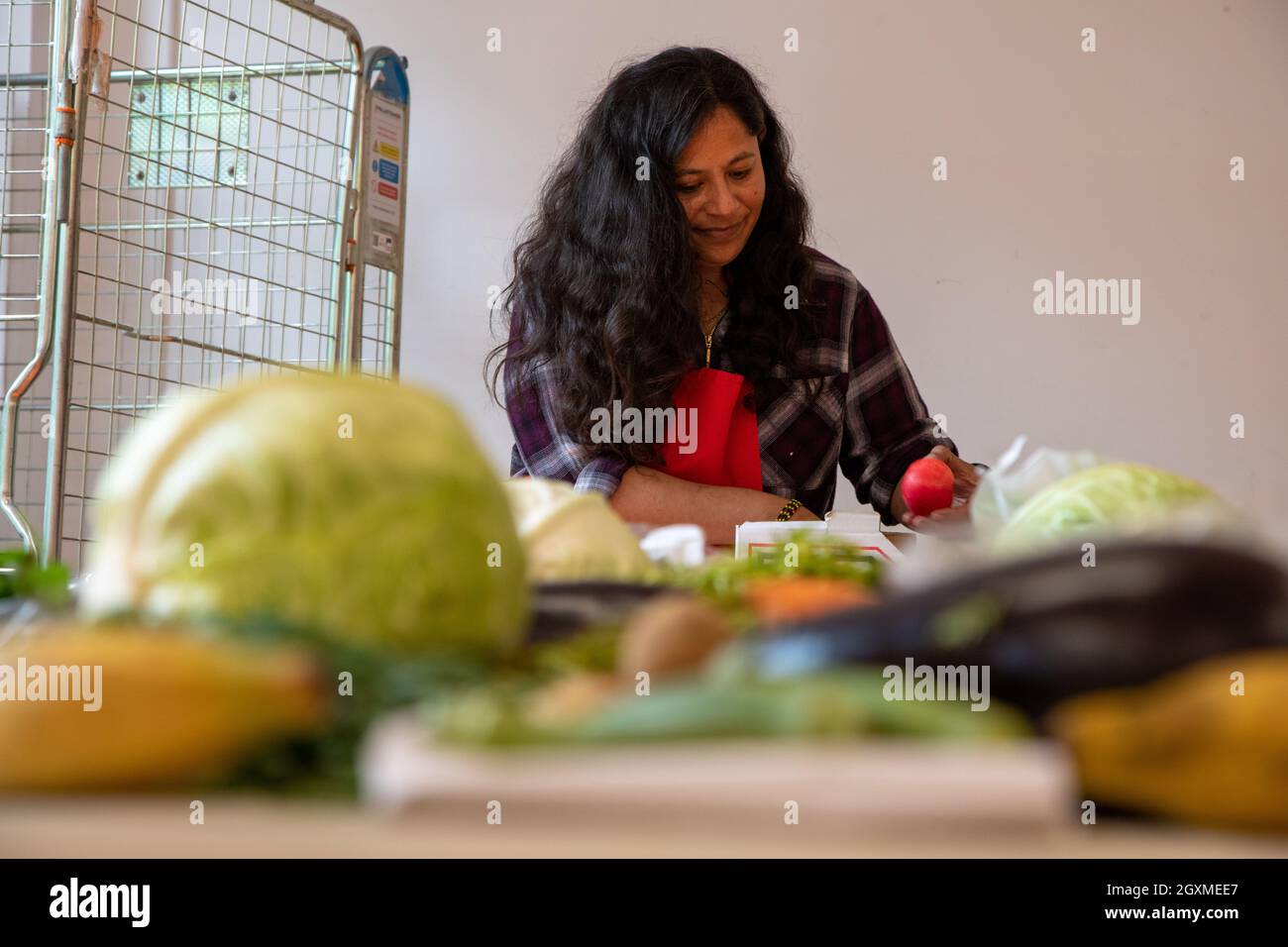 A woman packing apples into a fruit and vegetable box for customers at