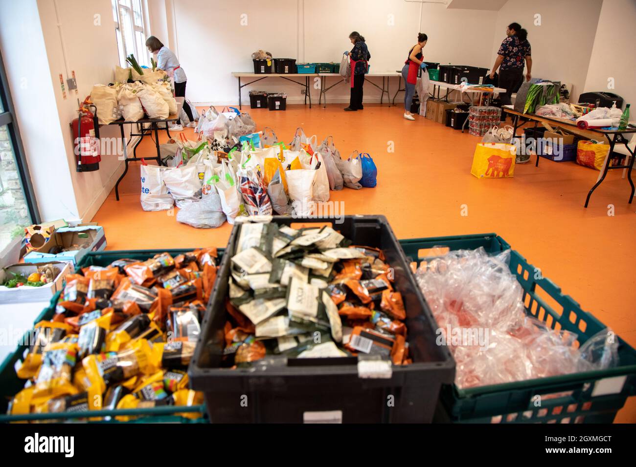 Volunteers at a food bank sorting crates of donated food in preparation