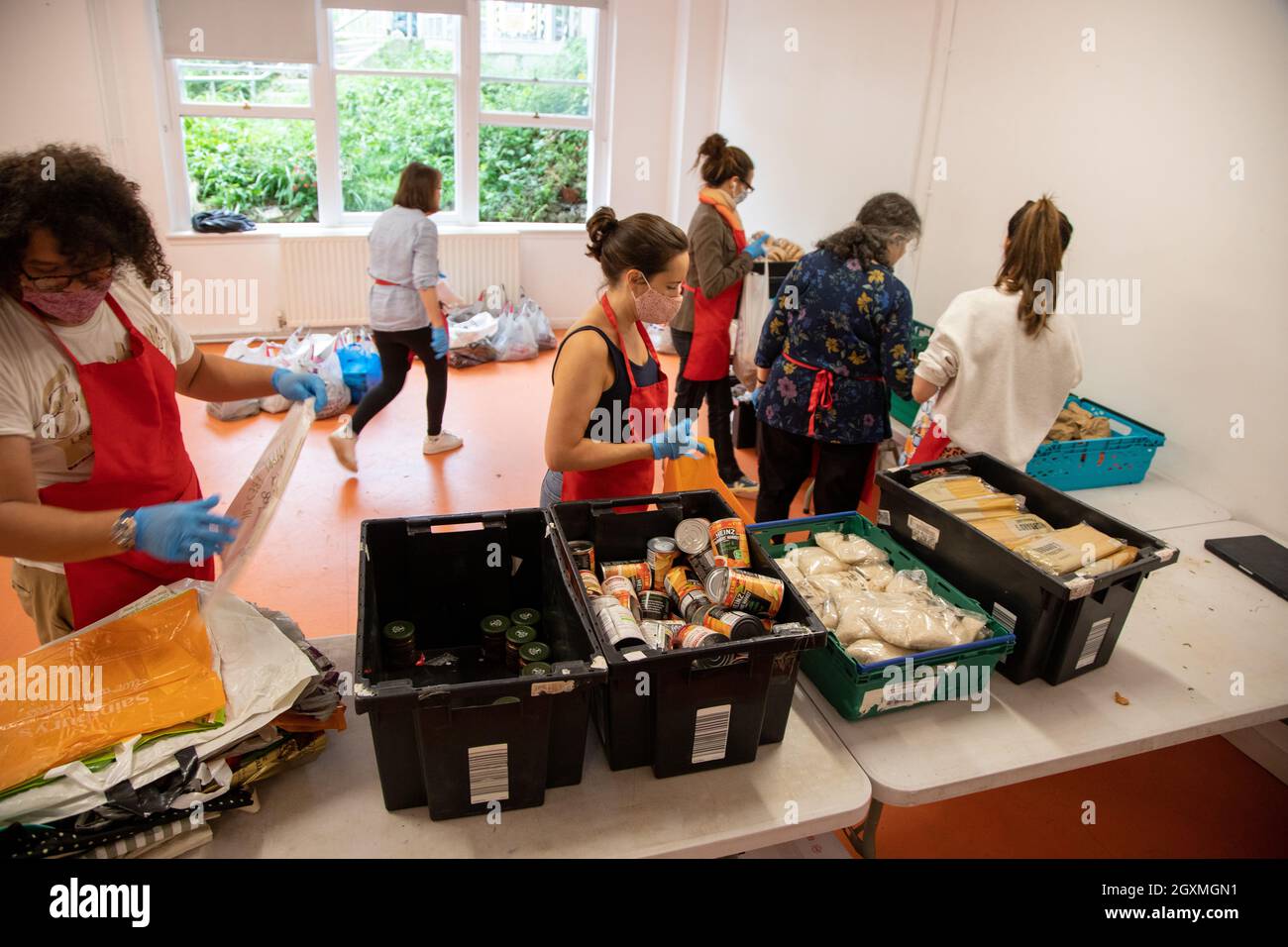 Volunteers at a food bank sorting crates of donated food in preparation