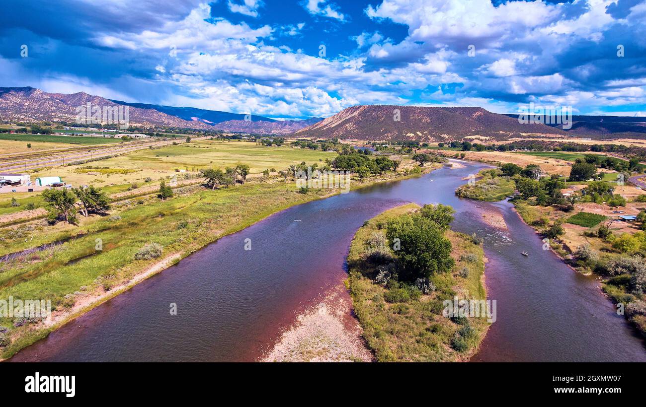Split river through lush forest by desert mountains Stock Photo Alamy