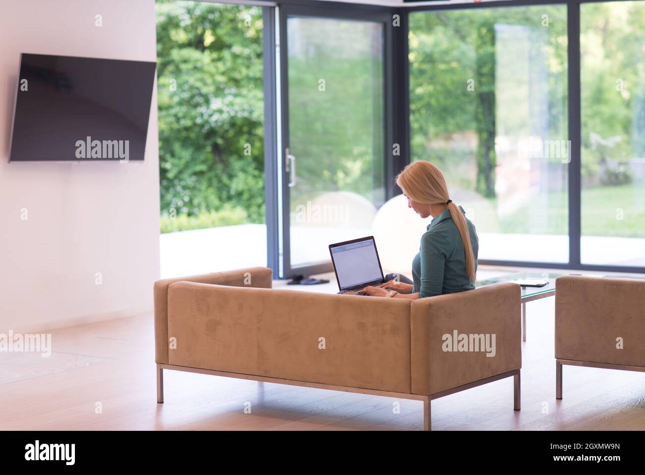 Young woman using her laptop computer in her luxury modern home ...