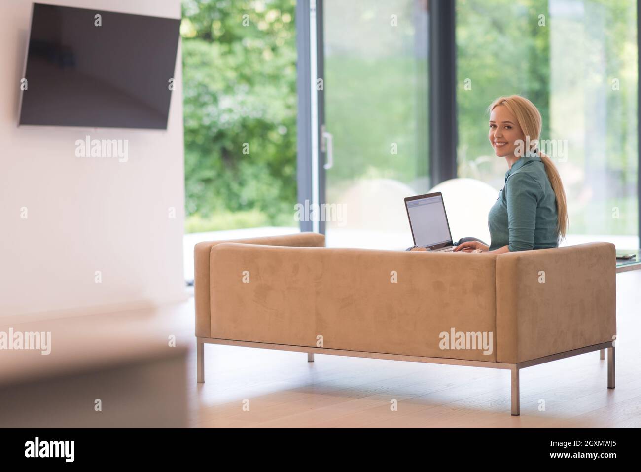 Young woman using her laptop computer in her luxury modern home ...