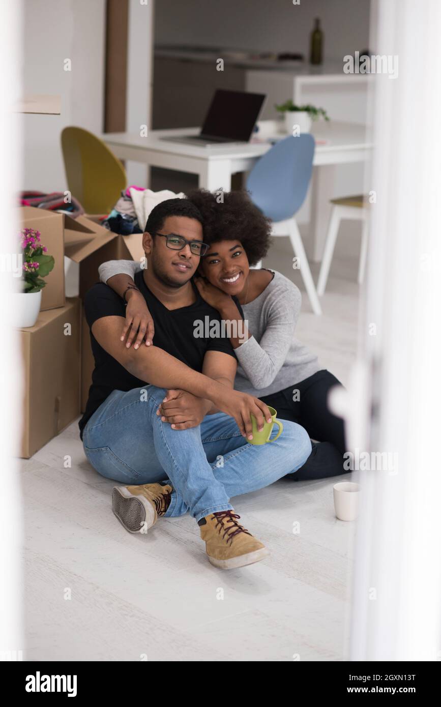 Relaxing in new house. Cheerful young African American couple sitting ...