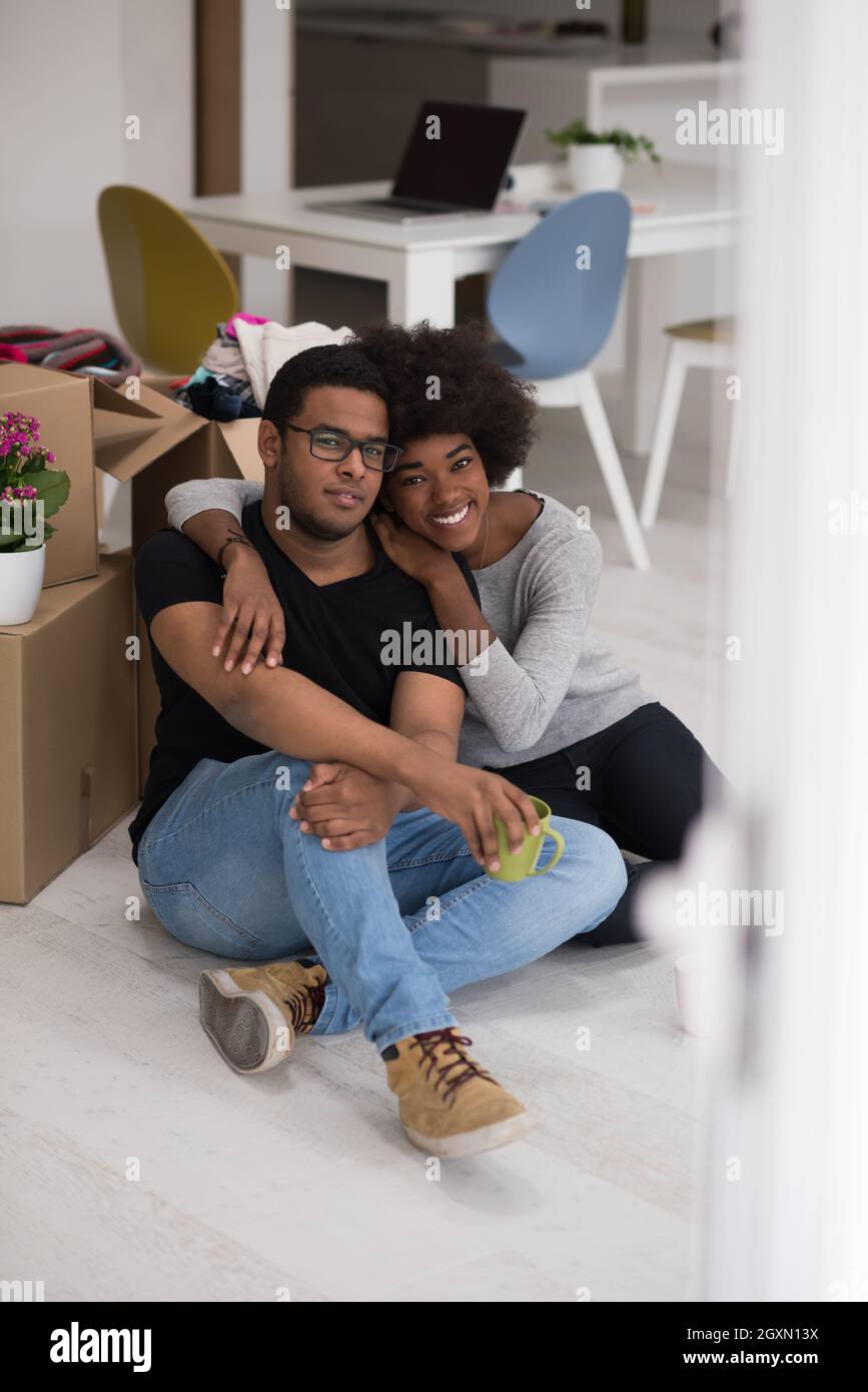 Relaxing in new house. Cheerful young African American couple sitting ...