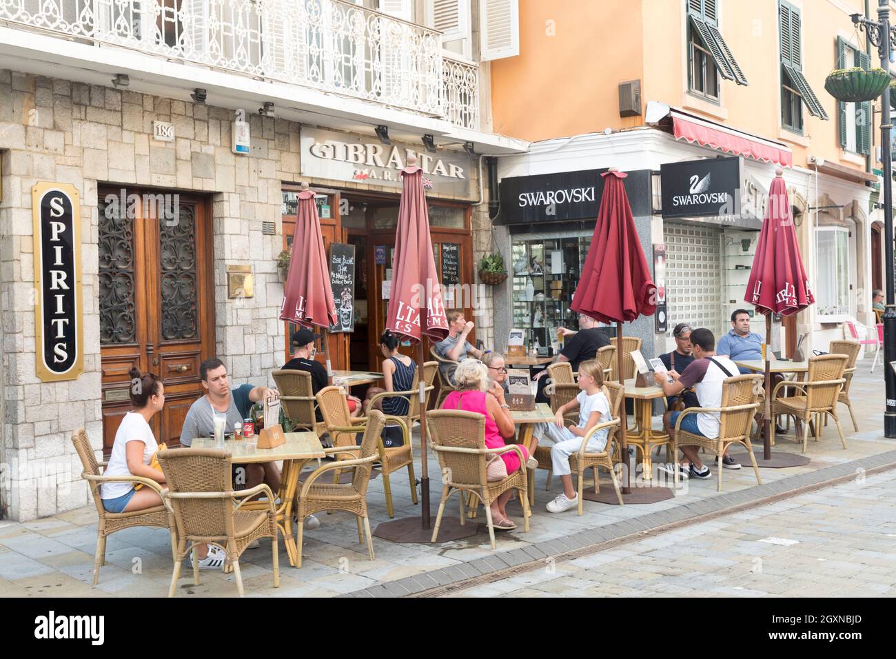 People eating and drinking at pavement tables and chairs, Gibraltar Stock Photo