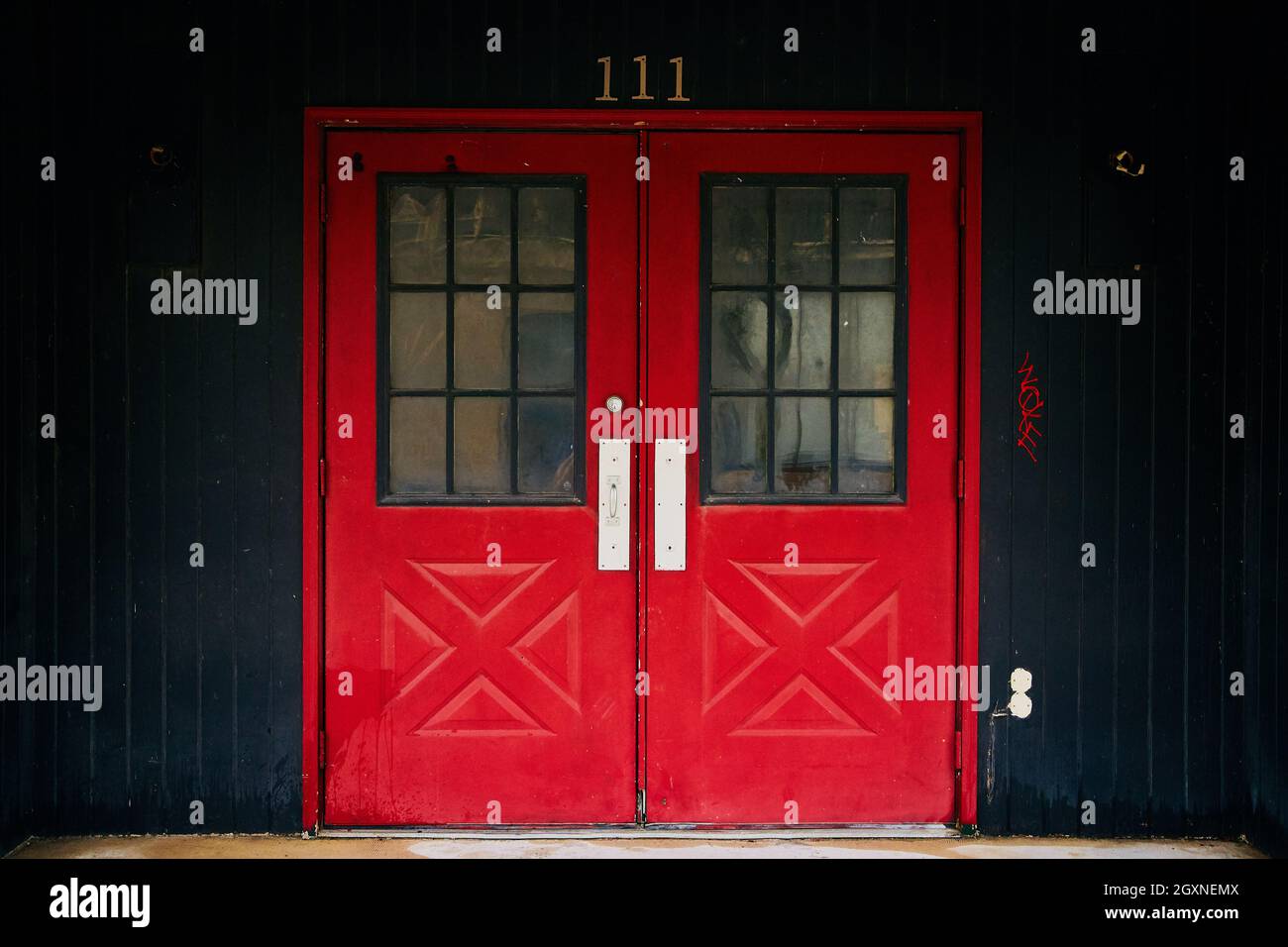 Double red doors to building 111 with black paneling Stock Photo Alamy