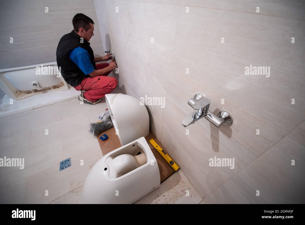 professional plumber working in a bathroom, plumbing repair service ...