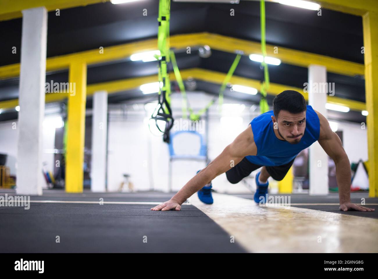 Young strong man doing pushups at cross fitness gym Stock Photo - Alamy