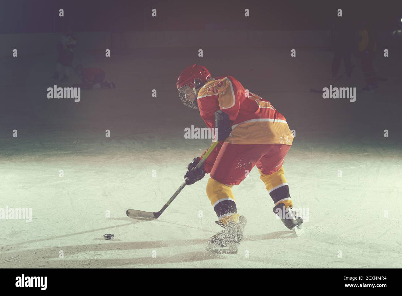 teen girl children ice hockey player in action kicking puck with stick