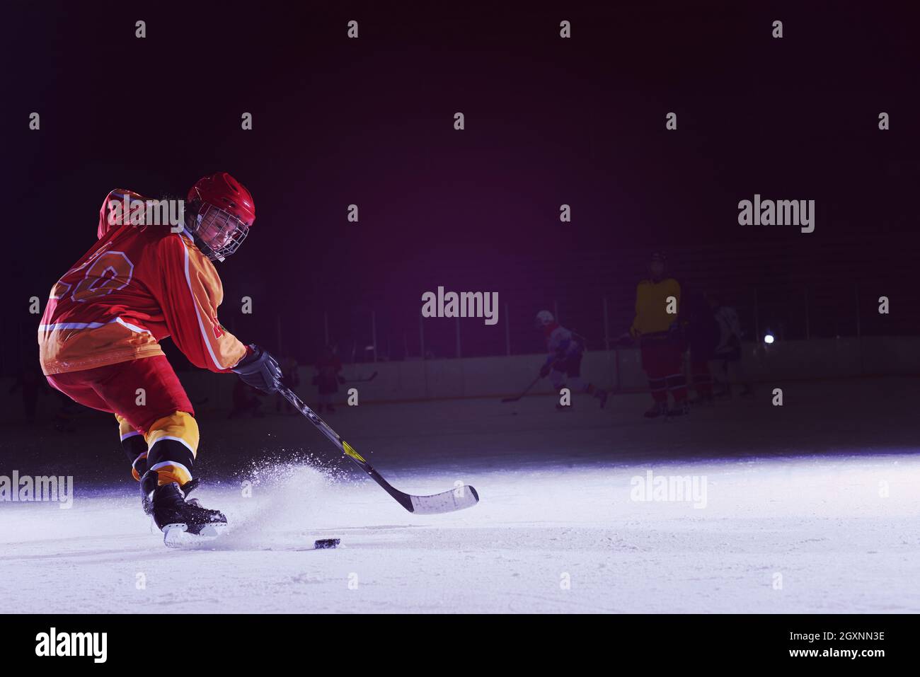 teen girl children ice hockey player in action kicking puck with stick