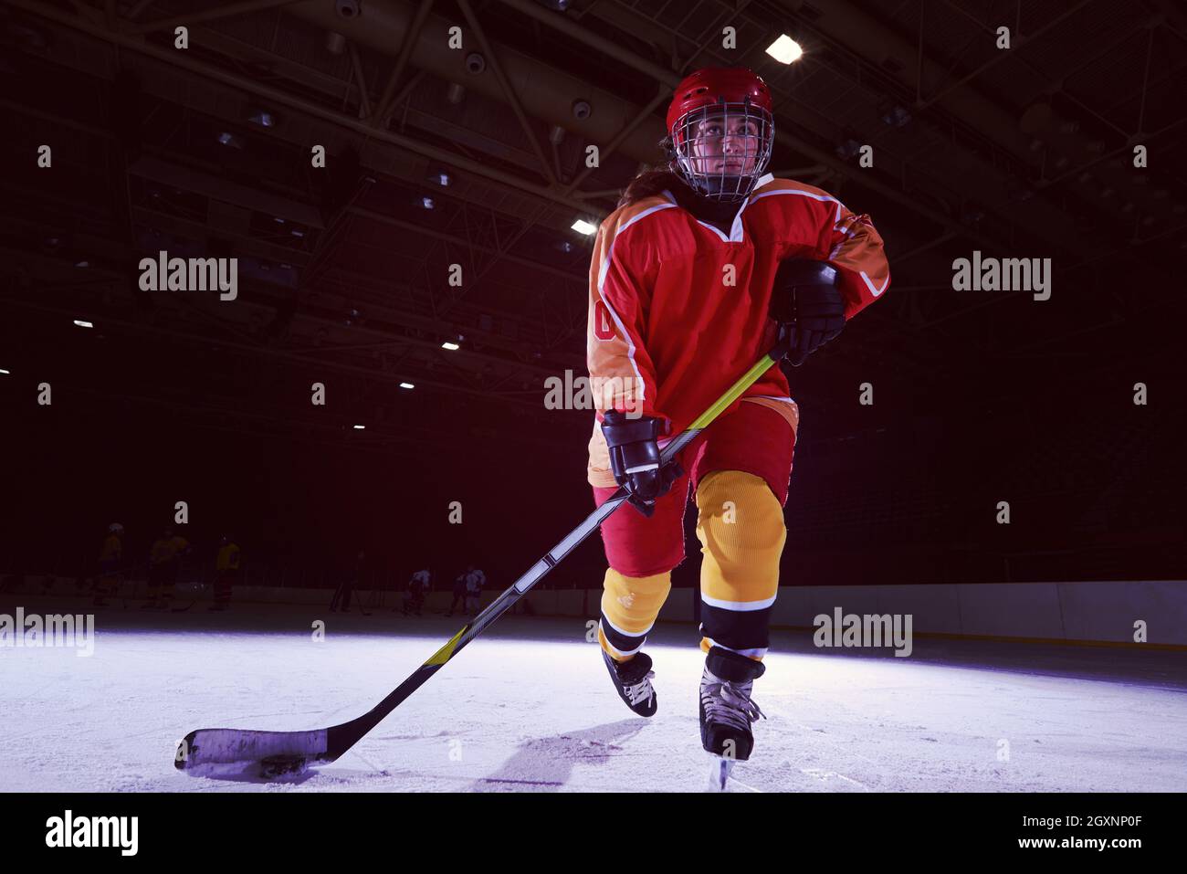teen girl children ice hockey player in action kicking puck with stick
